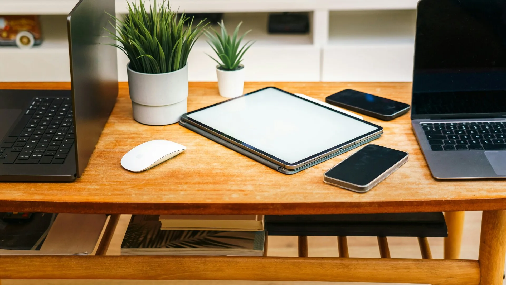 A desk with laptops, a tablet, and phones used for organizing online account access